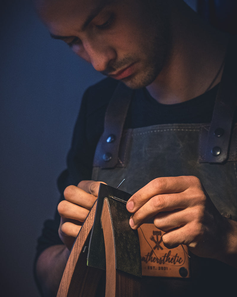 the crafter showing how he hand stiches 
